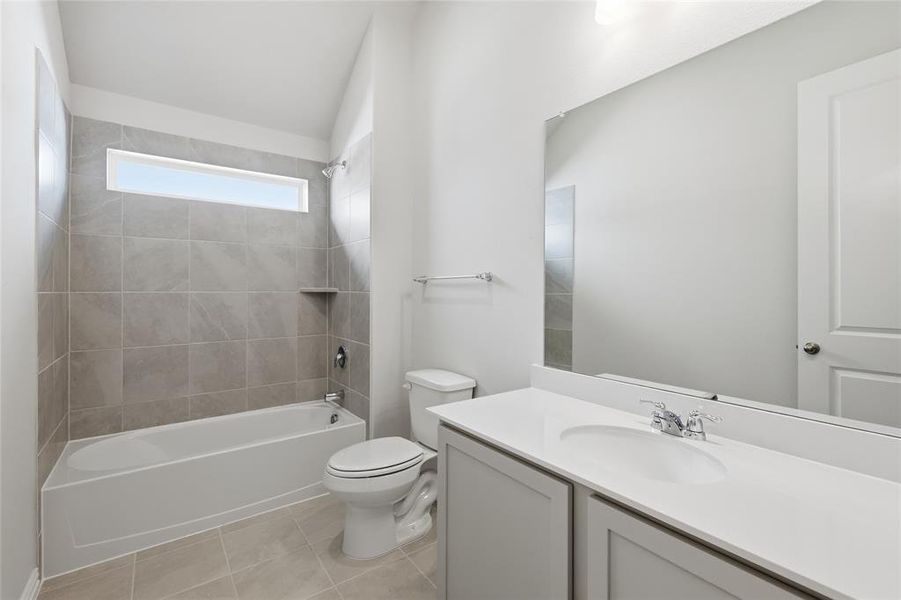 Full bath featuring vanity, shower / tub combination, and light tile patterned floors Full bath featuring vanity, shower / tub combination, and light tile patterned floors