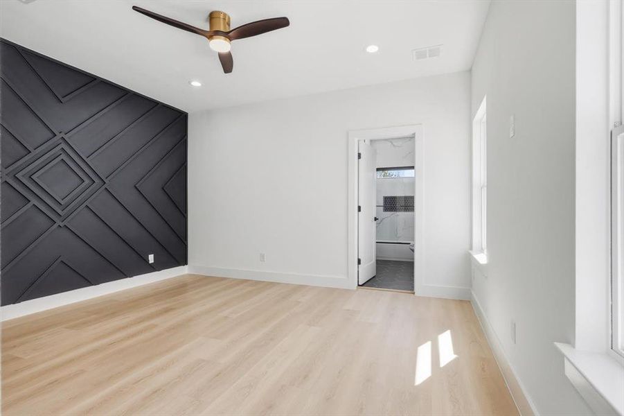 Accent wall featuring geometric paneling, wood-finish flooring, recessed lighting, and a modern ceiling fan Accent wall featuring geometric paneling, wood-finish flooring, recessed lighting, and a modern ceiling fan
