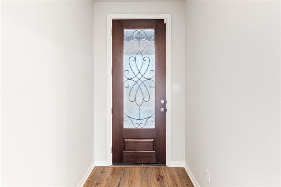 Doorway to outside with wood finished floors and baseboards