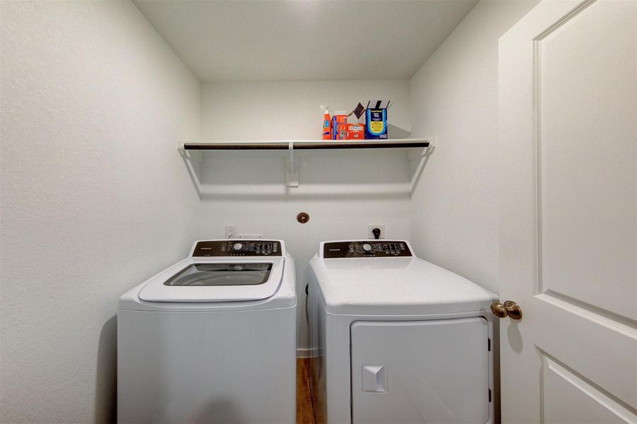 The laundry is conveniently located inside the house, at the end of the entry hallway.