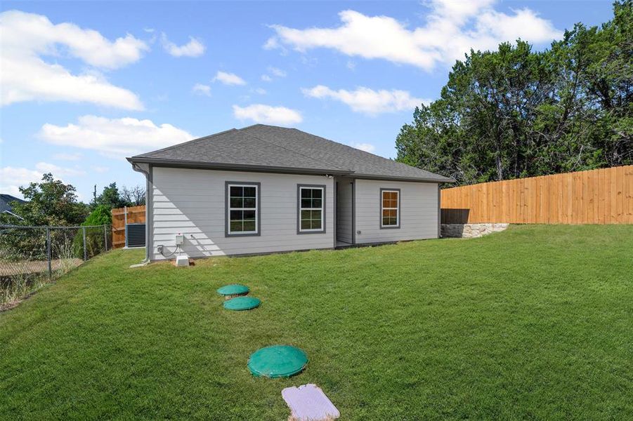 Rear view of house featuring a fenced backyard and a shingled roof Rear view of house featuring a fenced backyard and a shingled roof