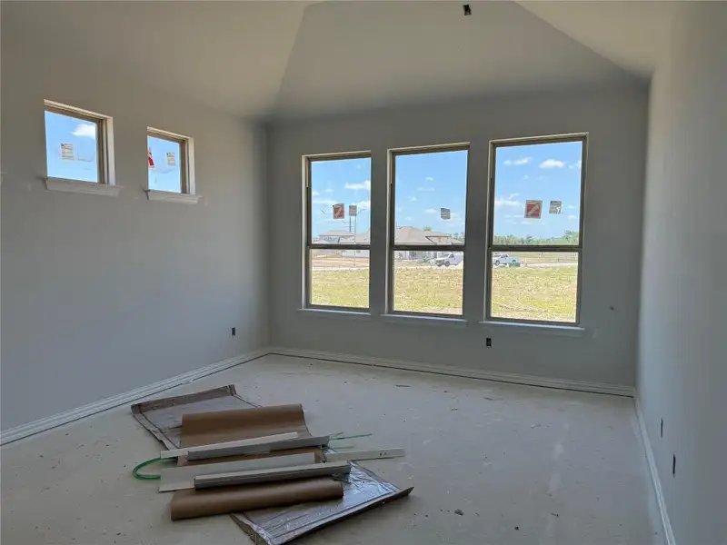 Unfurnished room with healthy amount of natural light and lofted ceiling Unfurnished room with healthy amount of natural light and lofted ceiling