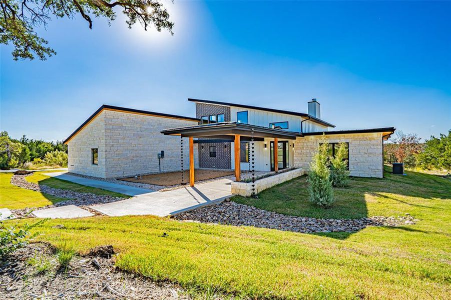 View of front of home with a front lawn, stone siding, a chimney, and a porch View of front of home with a front lawn, stone siding, a chimney, and a porch