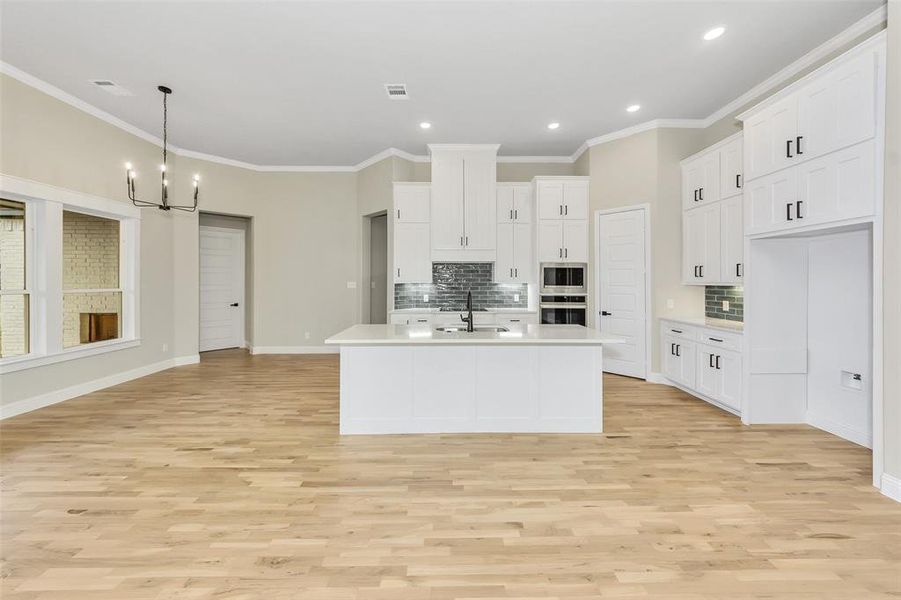 Kitchen with white cabinetry, light hardwood / wood-style flooring, and appliances with stainless steel finishes