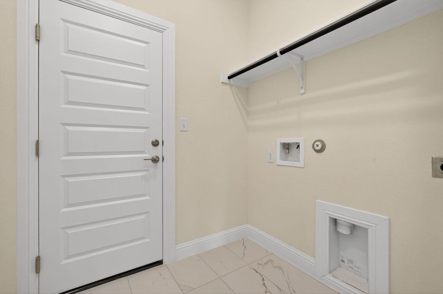 Laundry room with hookup for an electric dryer, hookup for a washing machine, light marble finish flooring, and hookup for a gas dryer