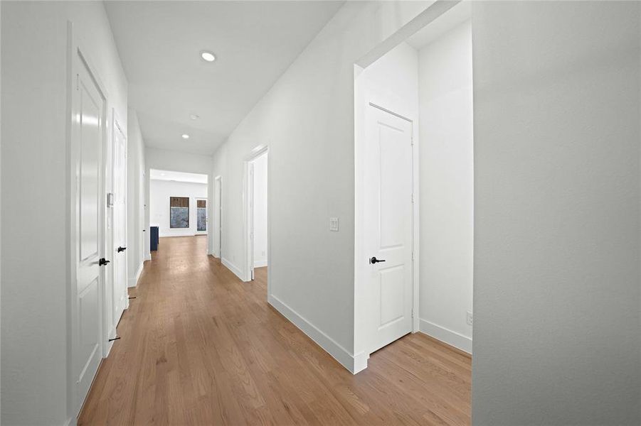 Hallway featuring light wood-style flooring and recessed lighting Hallway featuring light wood-style flooring and recessed lighting
