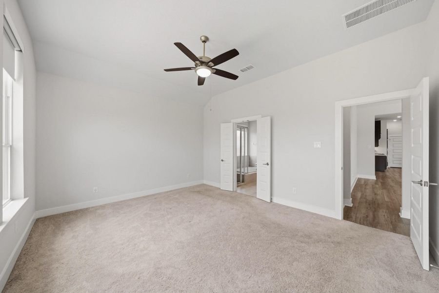 Generous primary bedroom with plush carpeting and abundant natural light. Generous primary bedroom with plush carpeting and abundant natural light.