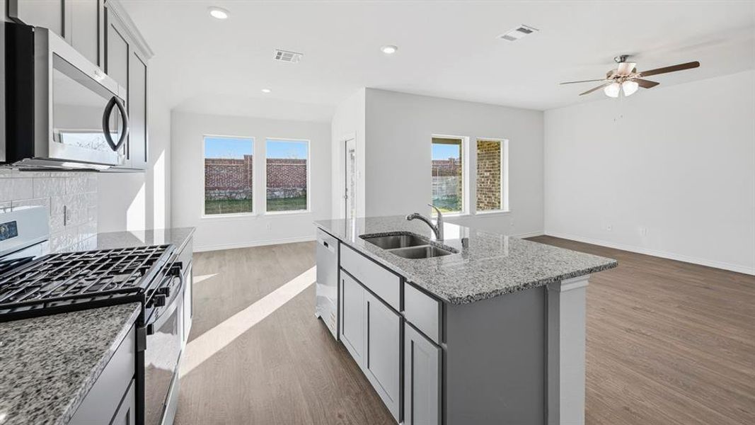 Modern kitchen with stainless steel appliances, granite countertops, and a subway tile backsplash