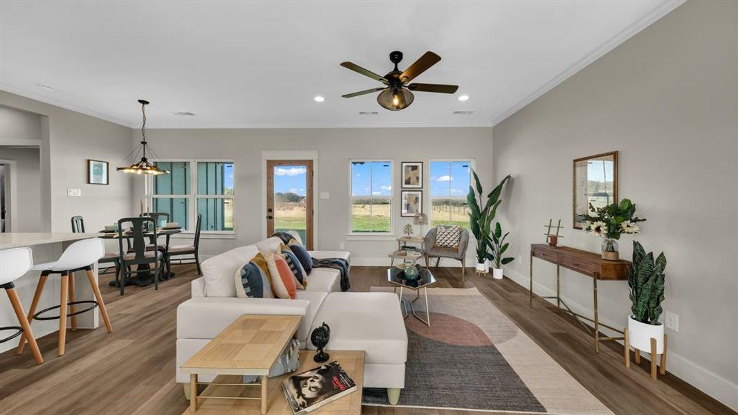 Living area featuring ornamental molding, wood finished floors, recessed lighting, and ceiling fan