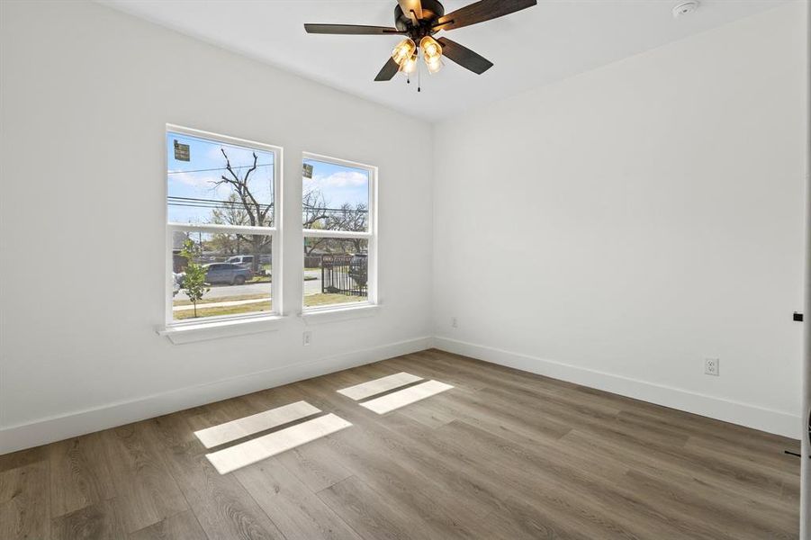 Spare room with a ceiling fan, wood finished floors, and baseboards