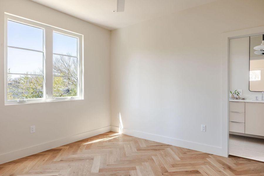 Primary bedroom features herringbone flooring like main floor.