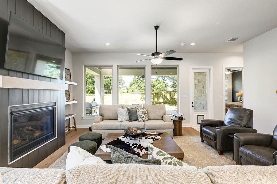 Living room featuring a glass covered fireplace, recessed lighting, and wood finished floors Living room featuring a glass covered fireplace, recessed lighting, and wood finished floors