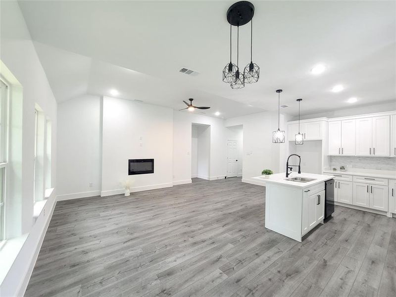 Kitchen featuring dishwashing machine, open floor plan, recessed lighting, light wood finished floors, and a ceiling fan Kitchen featuring dishwashing machine, open floor plan, recessed lighting, light wood finished floors, and a ceiling fan