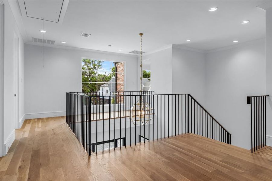 Corridor featuring ornamental molding and light hardwood / wood-style flooring