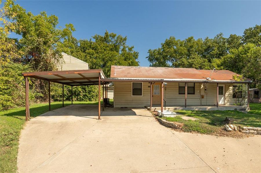 View of front facade featuring a front yard, a carport, and covered porch