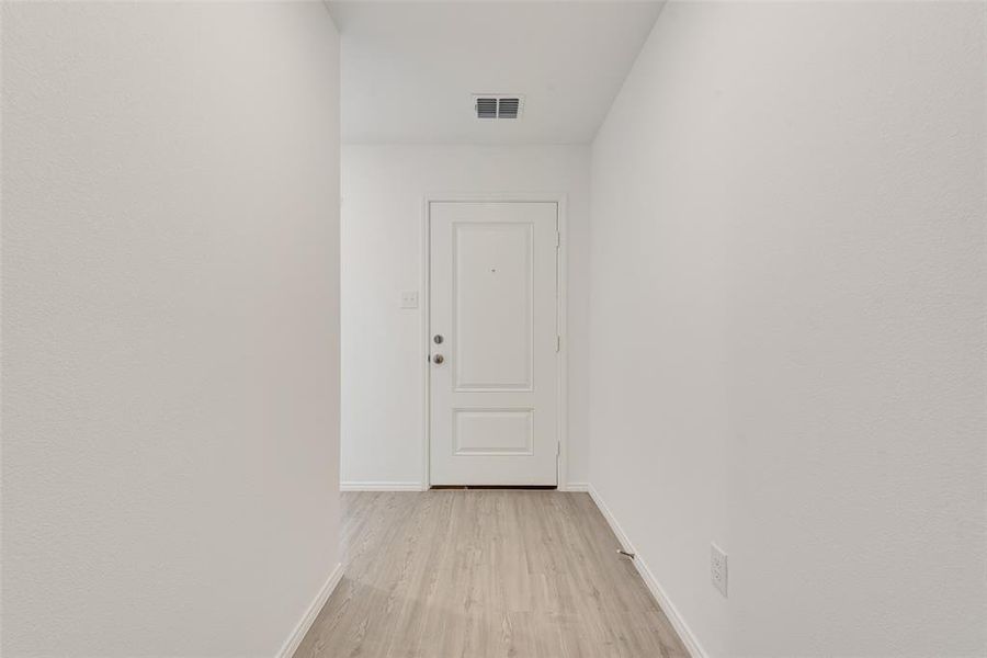 Corridor with light hardwood / wood-style flooring