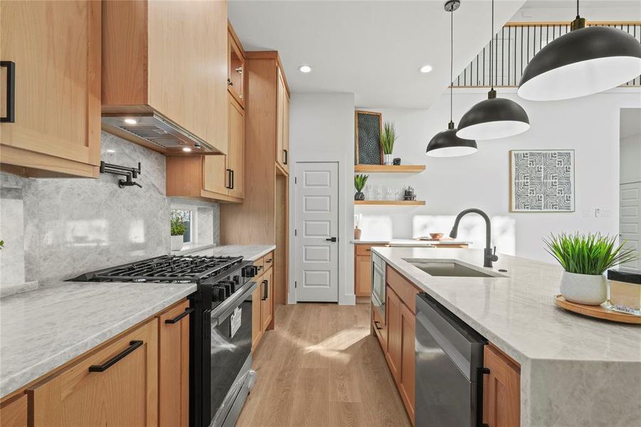 Kitchen featuring light stone counters, stainless steel appliances, light wood-style floors, open shelves, and backsplash