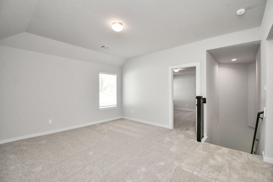 Come upstairs and enjoy a day of leisure in this fabulous game room! This is the perfect hangout spot or adult game room! Features plush carpet, high ceilings, custom paint and windows for plenty of natural light. Sample photo of completed home with similar floor plan. Actual colors and selections may vary.