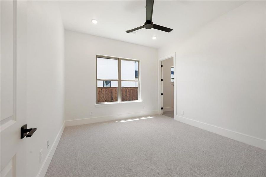 Carpeted empty room with ceiling fan