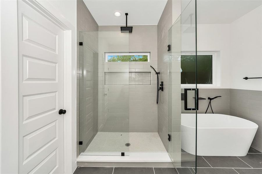 Full bath featuring a stall shower, tile patterned flooring, a soaking tub, and tile walls Full bath featuring a stall shower, tile patterned flooring, a soaking tub, and tile walls