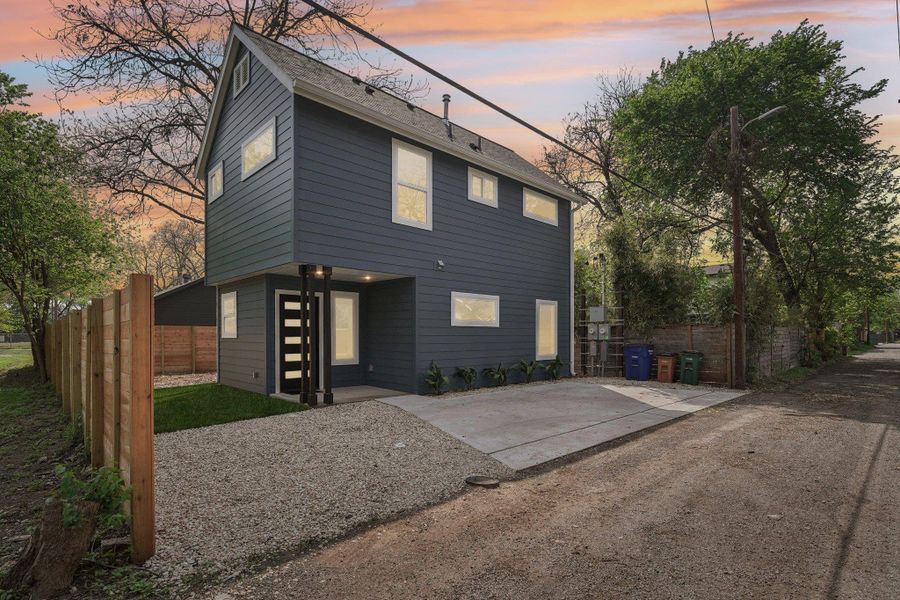 Rear view of property featuring fence and a shingled roof