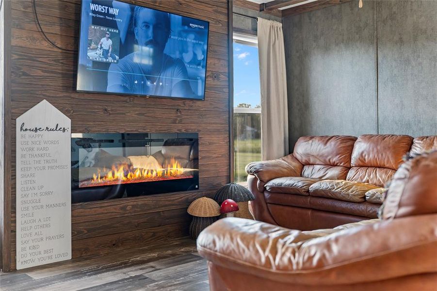 Living area with a large fireplace and wood finished floors Living area with a large fireplace and wood finished floors