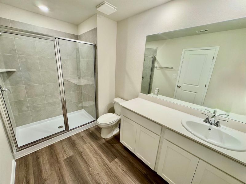 Full bathroom featuring vanity, a shower stall, and wood finished floors