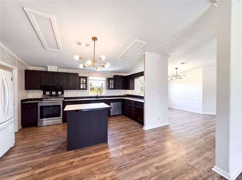 Dark cabinetry and wood-look flooring define this open kitchen design.
