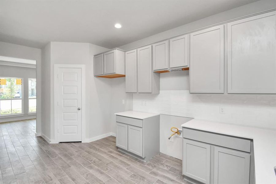 Culinary haven, featuring granite countertops, a tile backsplash, stainless steel appliances (to be installed), and 42” upper cabinets. Sample photo of completed home with similar floor plan. As-built interior colors and selections may vary.