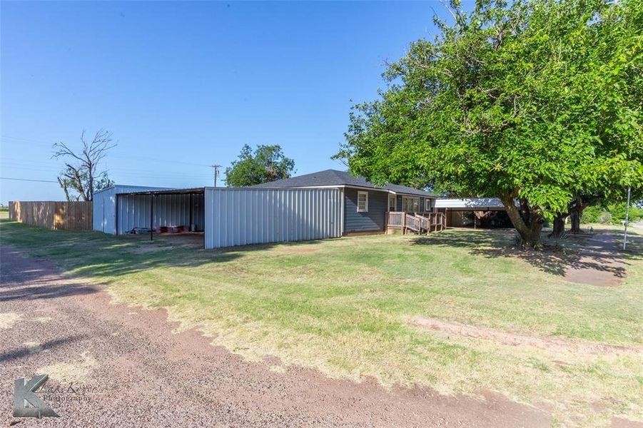 View of grassy yard with an outbuilding and an outdoor structure