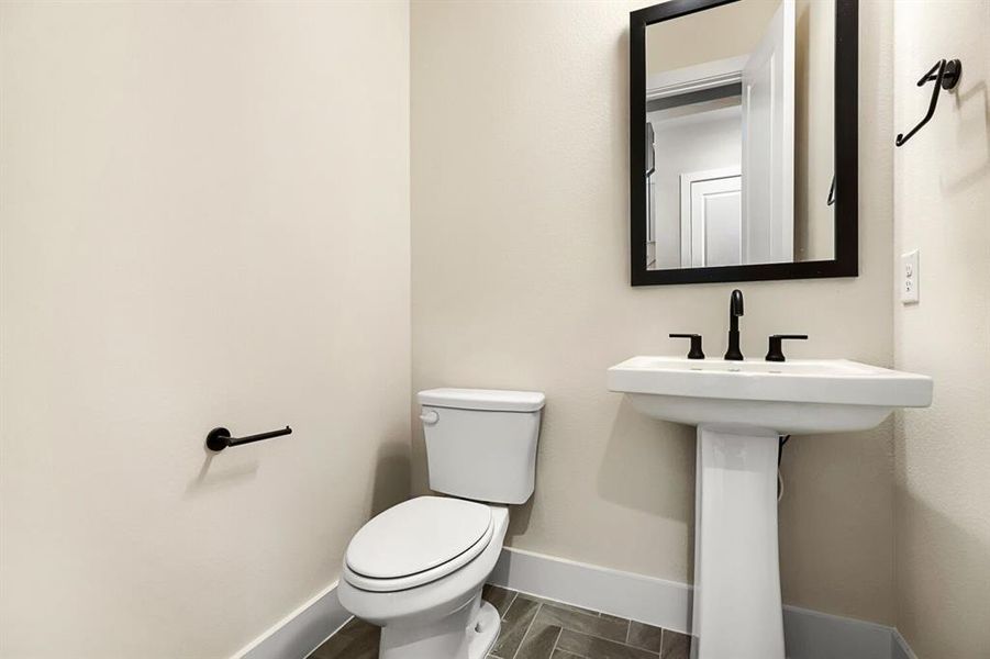 Half bathroom featuring toilet and baseboards Half bathroom featuring toilet and baseboards