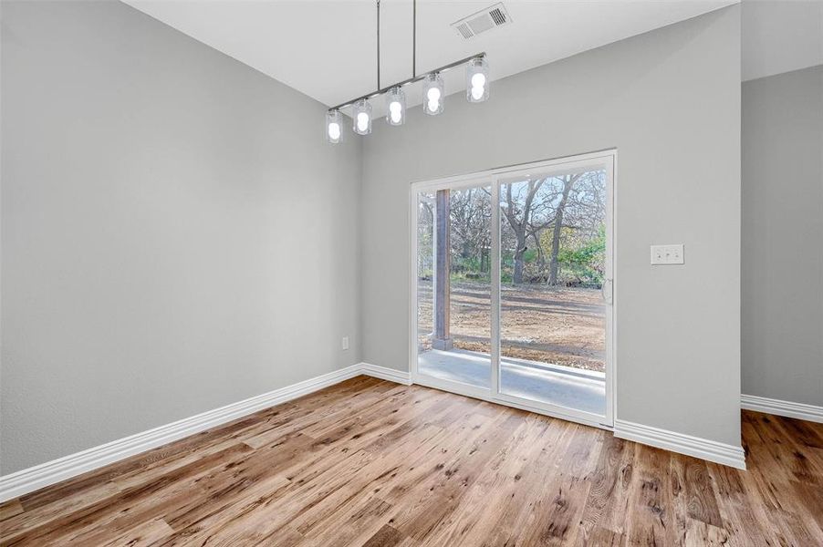 Unfurnished dining area featuring wood-type flooring and track lighting