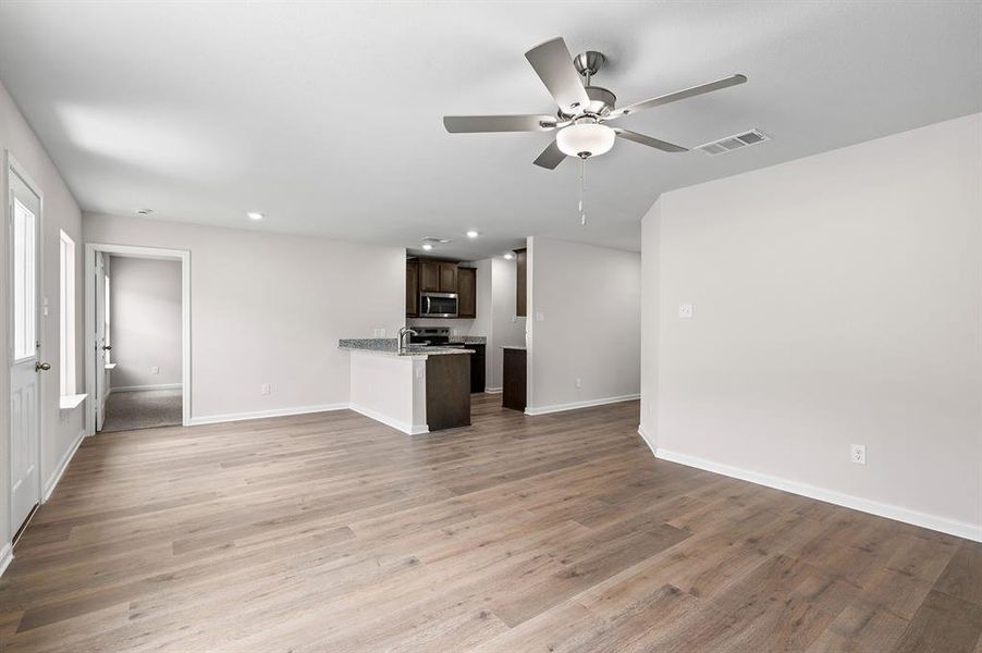 Unfurnished living room with a ceiling fan, recessed lighting, and wood finished floors