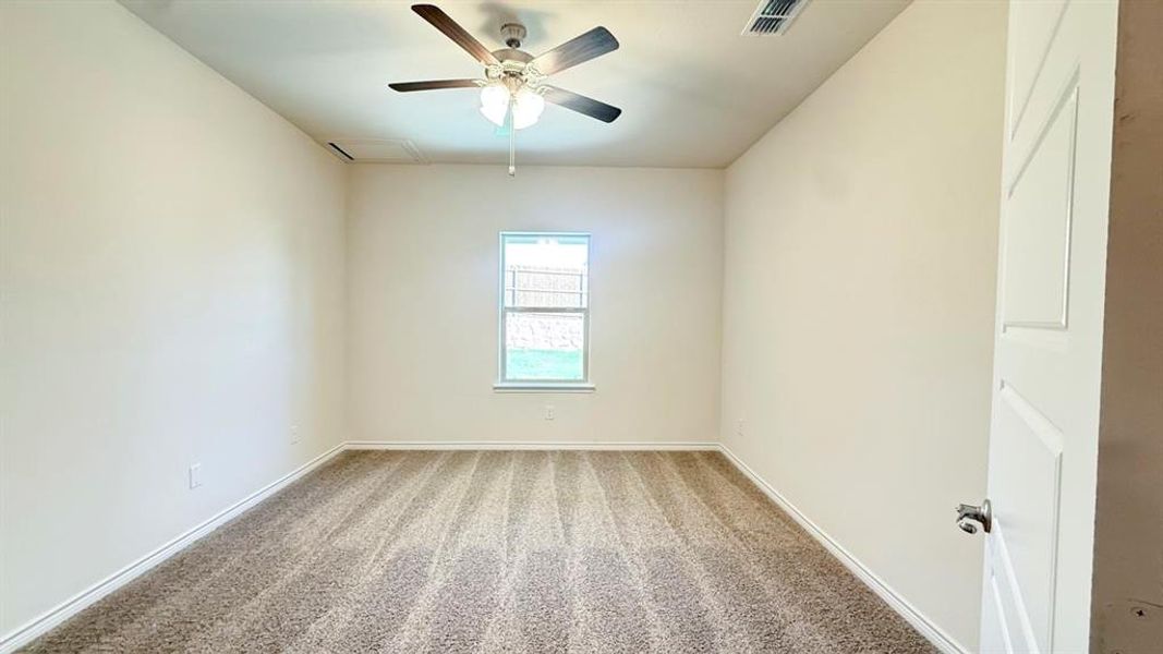 Carpeted empty room with baseboards and a ceiling fan