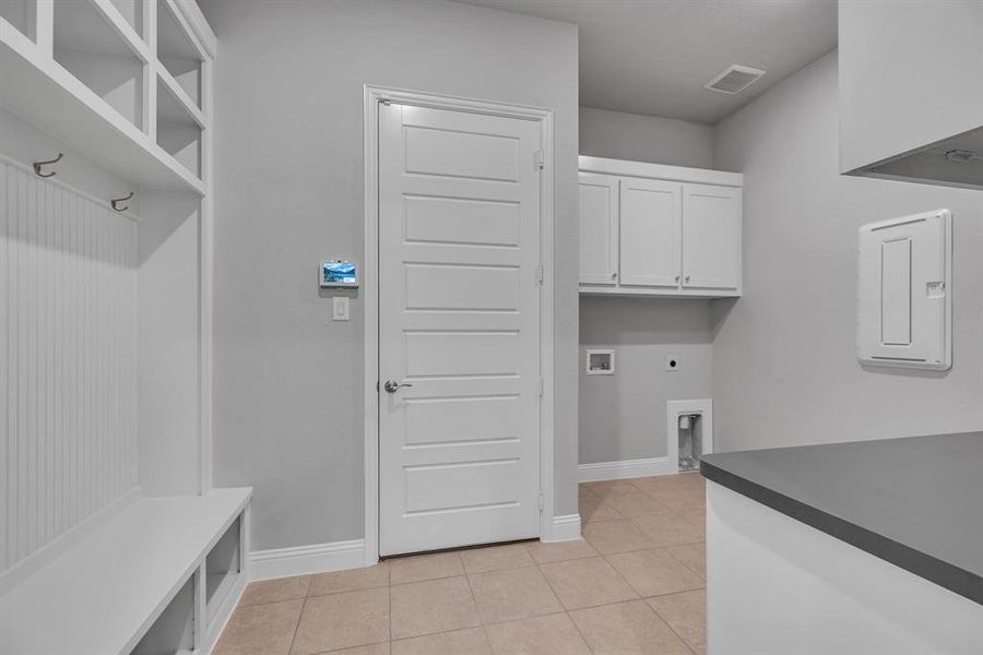 Laundry area featuring hookup for a washing machine, cabinets, electric dryer hookup, and light tile patterned flooring