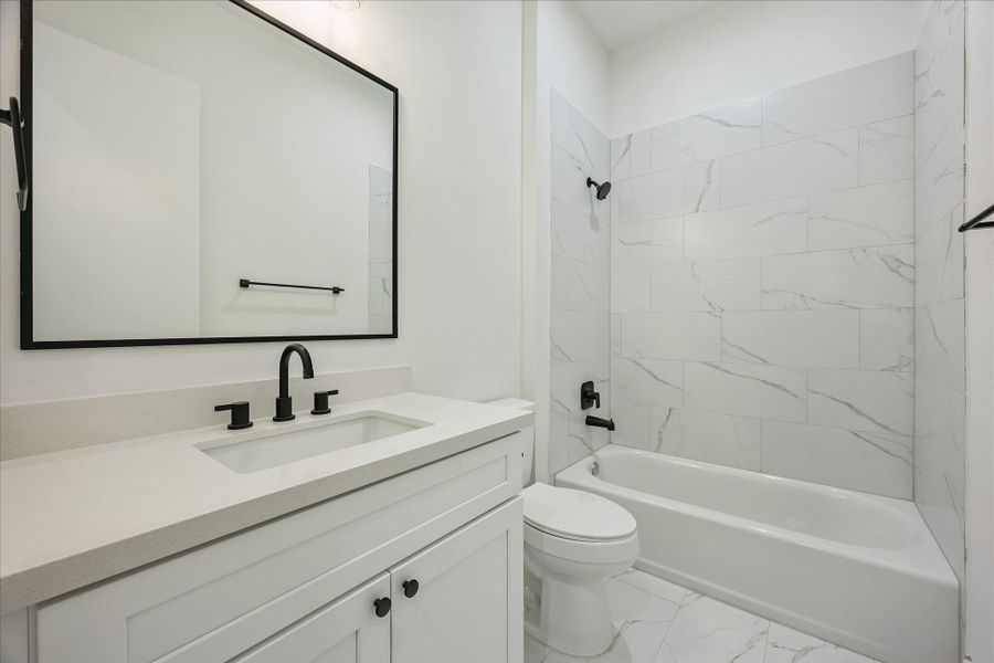 The secondary bedroom's ensuite bath is equally well appointed, featuring quartz countertops, designer tile, and a tub/shower combination. The secondary bedroom's ensuite bath is equally well appointed, featuring quartz countertops, designer tile, and a tub/shower combination.
