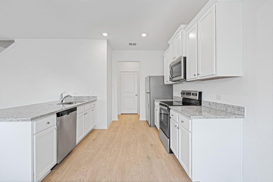 Energy-efficient Whirlpool® appliances, gorgeous granite countertops, and designer wood cabinets with crown molding detail