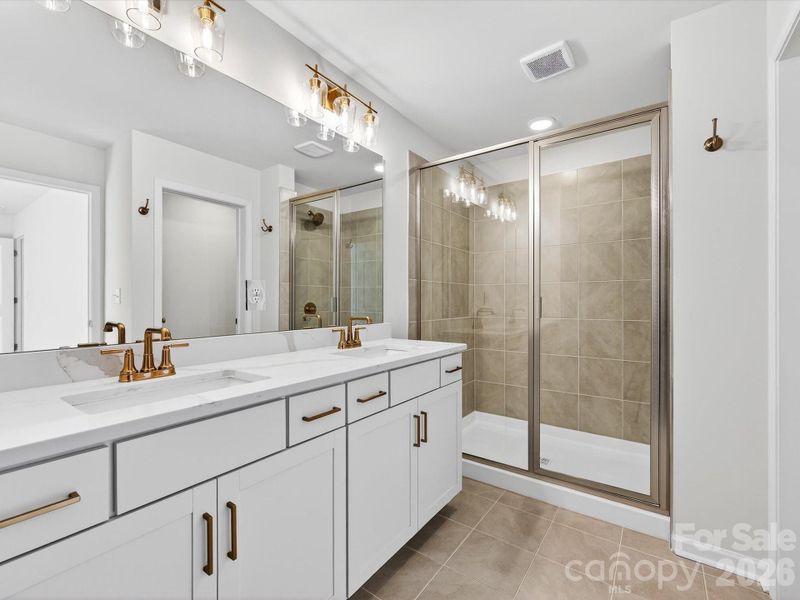 Dual vanity in primary bath feature quartz countertops, soft close drawers and cabinet doors. Tiled shower with bench- separate toilet and large walk-in closet Dual vanity in primary bath feature quartz countertops, soft close drawers and cabinet doors. Tiled shower with bench- separate toilet and large walk-in closet