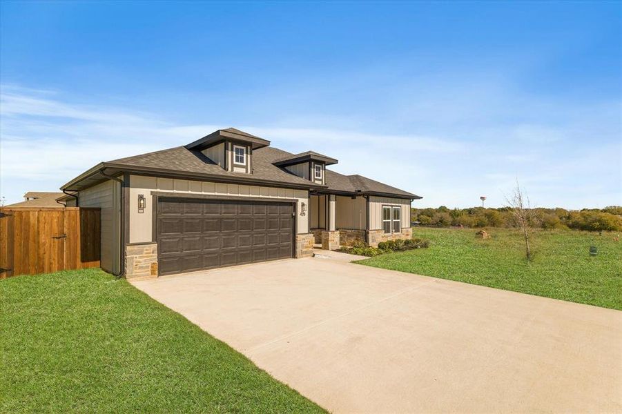 Prairie-style home featuring a garage and a front lawn Prairie-style home featuring a garage and a front lawn