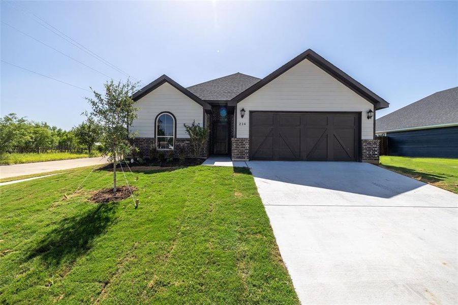 View of front of property featuring a garage and a front yard