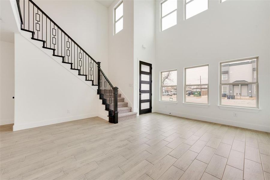 Entrance foyer with baseboards, plenty of natural light, light wood finished floors, and stairs