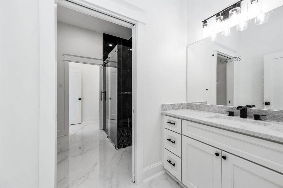 Jack-and-Jill bathroom featuring separate vanities, a shared walk-in shower, and sleek black finishes throughout. Jack-and-Jill bathroom featuring separate vanities, a shared walk-in shower, and sleek black finishes throughout.