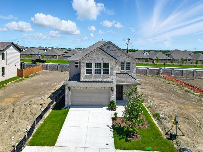 View of front facade featuring an attached garage, brick siding, driveway, and a residential view View of front facade featuring an attached garage, brick siding, driveway, and a residential view