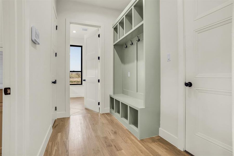 Mudroom with light wood finished floors and baseboards