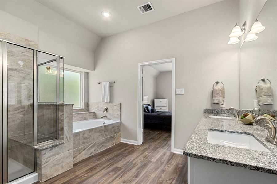 Walk in through the double doors to a large en suite bathroom including double sinks, granite counters, separate shower and soaking tub, and spacious master closet.