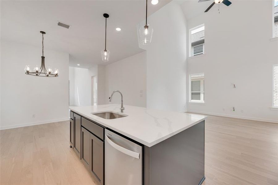 Kitchen with pendant lighting, stainless steel dishwasher, open floor plan, light wood-style floors, and recessed lighting Kitchen with pendant lighting, stainless steel dishwasher, open floor plan, light wood-style floors, and recessed lighting