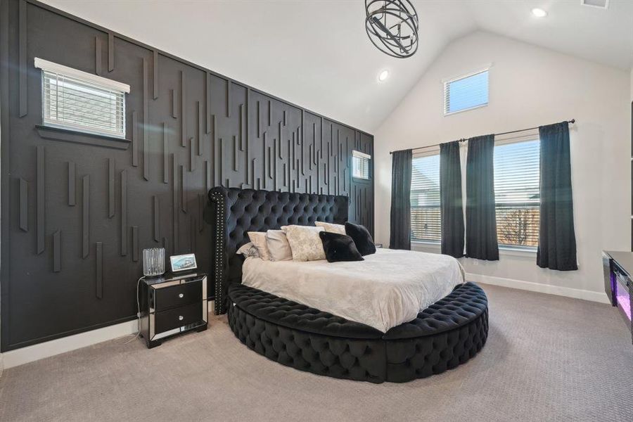 Bedroom featuring light colored carpet, lofted ceiling, and multiple windows