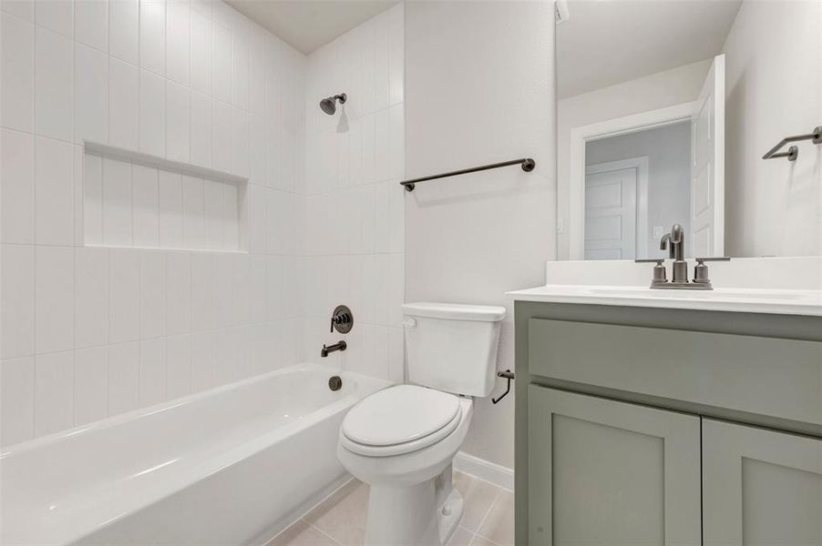 Bathroom featuring a tub/shower combination with a recessed niche, white tiled walls, and matte black fixtures