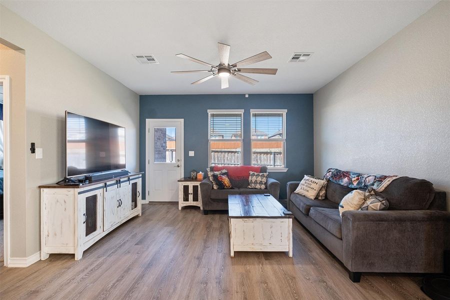 Modern living room with natural light and open to other living spaces.