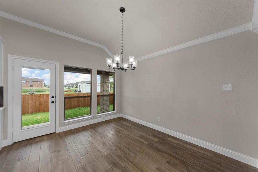 Wood-finish tile flooring complemented by a vaulted ceiling with crown molding